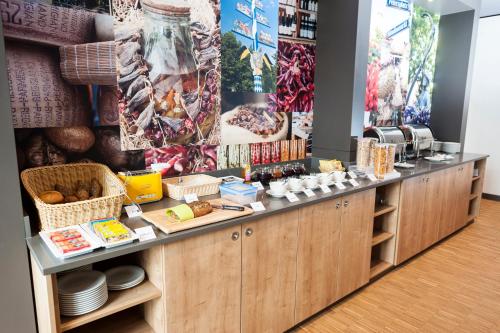 a kitchen with a counter with food on it at BEST WESTERN Hotel The K Unterföhring in Munich