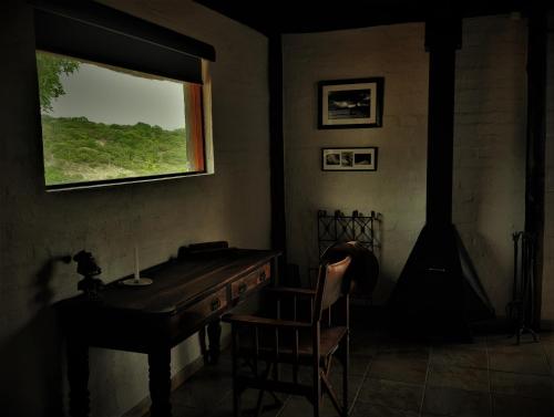 a room with a desk and a window and a chair at Graceland Eco Retreat in Magoebaskloof