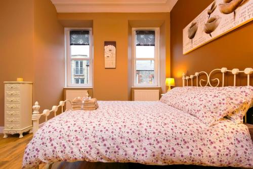 エディンバラにあるStylish Apartment near Royal Mileのベッドルーム1室(ベッド1台、窓2つ付)