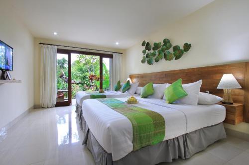 a bedroom with two beds and a television at Bucu View Resort in Ubud