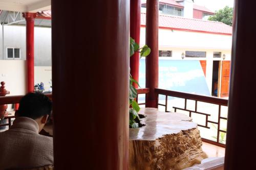 a man sitting at a table on a balcony at Moc Chau Town - Homestay in Mộc Châu