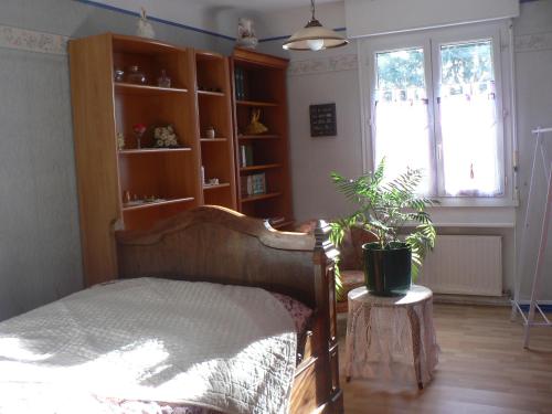 a bedroom with a wooden bed and a potted plant at Clo Hujobe in Parthenay