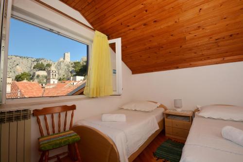 a bedroom with two beds and a window at Apartment Mimica-Croatia , Omis , Center in Omiš