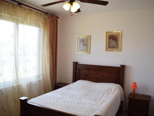 a bedroom with a bed with a ceiling fan and a window at Vacations in the Caribbean Paradise in Sosúa