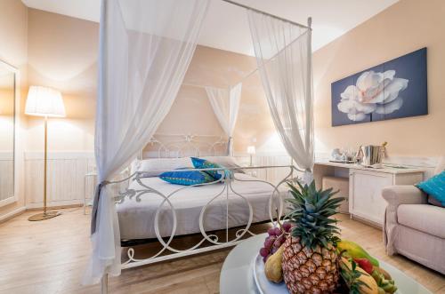 una camera con letto a baldacchino e tavolo con cesto di frutta di Albergo Ristorante La Palma a Bissone