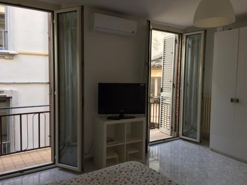 um quarto com uma televisão e uma varanda com uma televisão gmaxwell gmaxwell gmaxwell em La Casetta Due em Teramo