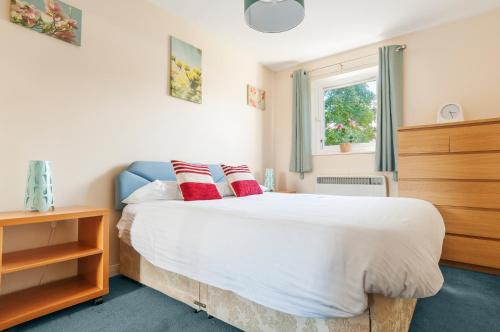 a bedroom with a bed with red pillows on it at Polwarth Apartment in Edinburgh