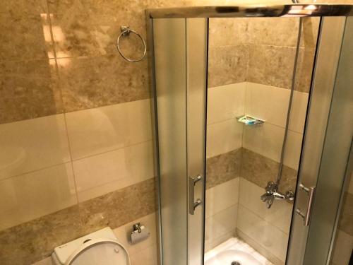 a bathroom with a shower and a toilet at Shamat Jeddah Furnished Units in Jeddah