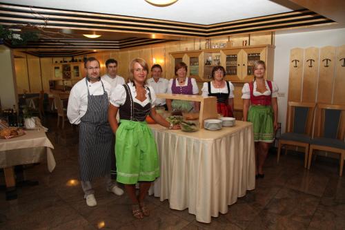 a group of people standing around a table at Hotel Dolomitenblick in Terento