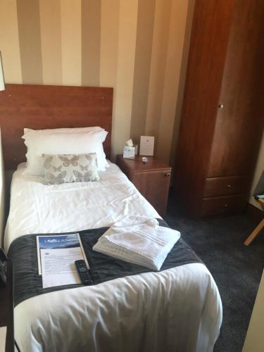 una habitación de hotel con una cama con un libro encima en The Globe Inn en Gosforth