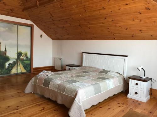 a bedroom with a bed and a wooden ceiling at Приватний будинок для сімейного відпочинку з басейном і сауною in Hryhorivka