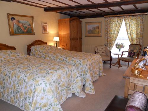 a hotel room with two beds and a chair at Denmark House in Long Melford