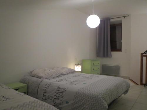 a bedroom with two beds and a lamp and a window at T1 centre ville Aubenas in Aubenas