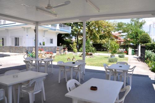 a group of tables and chairs under a white umbrella at Armiriki Rooms in Vrasná