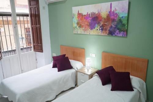 sypialnia z 2 łóżkami i obrazem na ścianie w obiekcie Antares w Grenadzie