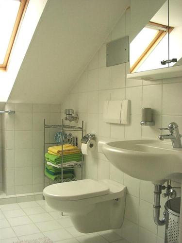 Baño blanco con lavabo y aseo en Konstanz-Wallhausen, en Constanza