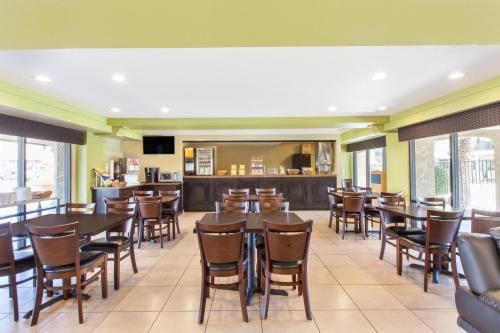 a restaurant with tables and chairs and a bar at Days Inn by Wyndham San Jose Airport in Milpitas