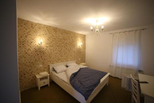 a small bedroom with a bed and a chandelier at Fresh Accommodation in Rădăuţi