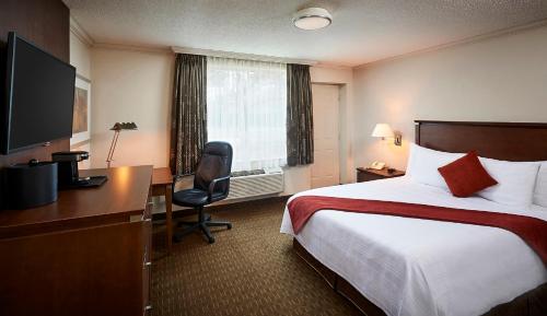 a hotel room with a bed and a desk at Best Western Plus Guildwood Inn in Sarnia