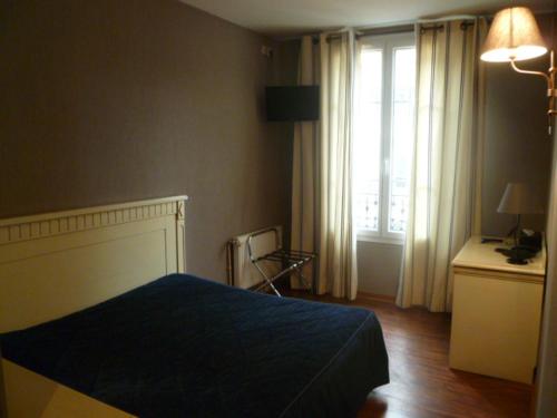 ein Schlafzimmer mit einem blauen Bett und einem Fenster in der Unterkunft Au limousin in Levallois-Perret