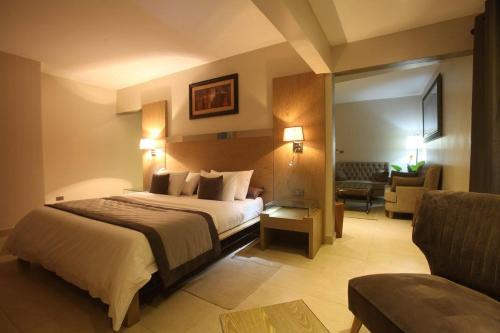 a hotel room with a bed and a couch at Hotel VDN by Good Rade in Dakar