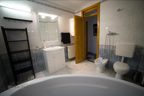 a bathroom with a tub and a toilet and a sink at Studio 35 Busteni in Buşteni