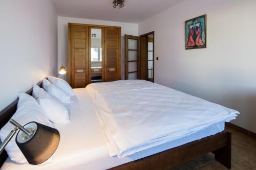 ein Schlafzimmer mit einem großen Bett mit weißer Bettwäsche und Kissen in der Unterkunft Dvojdům Ostrov u Macochy in Ostrov u Macochy
