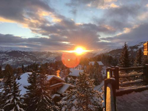 a view of the sun setting over a snowy mountain at Studio in Les Collons