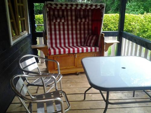 2 Stühle und ein Tisch auf einer Veranda in der Unterkunft Blokhut Meerland in Oostwold