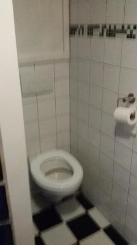 bagno con servizi igienici e pavimento in bianco e nero. di Blokhut Meerland a Oostwold