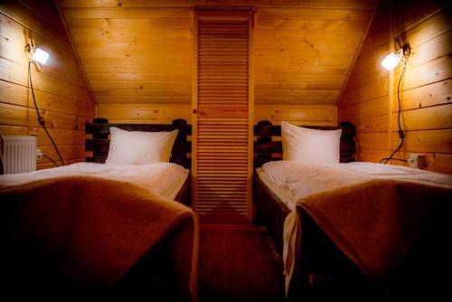 イズキにあるКотедж "Газда"のベッド2台 木製の壁の部屋