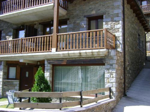 a building with a wooden balcony and a bench at Gauach in Bossost