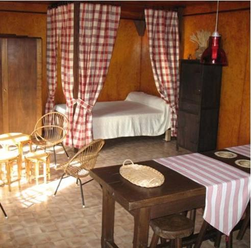 サン・ローラン・シュル・セーヴルにあるLa Cabane du Commandeurのベッド、テーブル、椅子が備わる客室です。