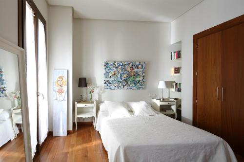 1 dormitorio con 1 cama, 2 mesas y un cuadro en Veoapartment Corral del Rey 5, en Sevilla