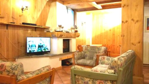 a living room with two chairs and a television at Residence Bait da Mott in Livigno