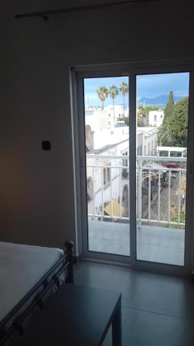 a room with a large window with a view of a balcony at Milva Apartments in Kos Town
