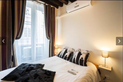 a small bedroom with a bed with a window at Apartment Duplex Paris in Paris