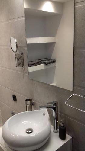 a bathroom with a white sink and a mirror at Milva Apartments in Kos Town
