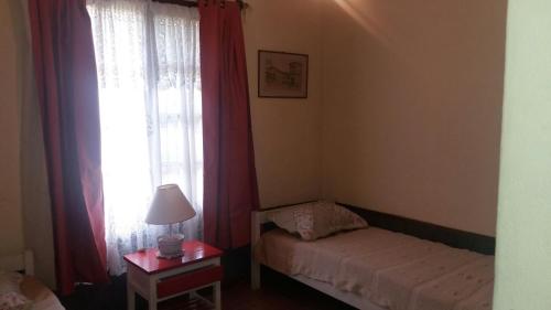 a small bedroom with a bed and a window at Villa Cristina in Punta del Este