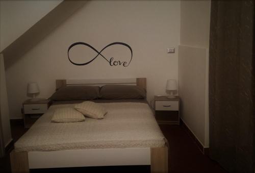um quarto com uma cama com a palavra amor na parede em A 100 passi da Calarossa em Siracusa