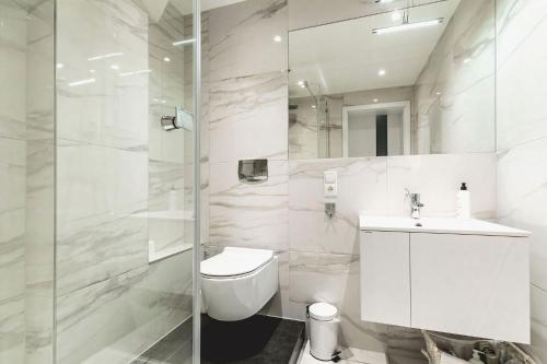 ルブリンにあるArtist Apartamentの白いバスルーム(トイレ、シンク付)