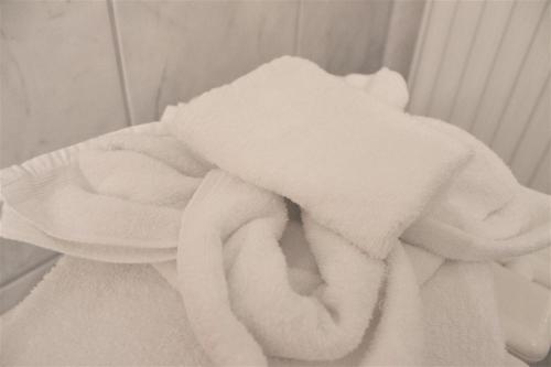 una pila de toallas blancas sentadas en una pared en Hotel America, en Ramstein-Miesenbach