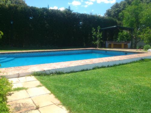una piscina en un patio con césped en El Campito - CASA RURAL, en Ronda