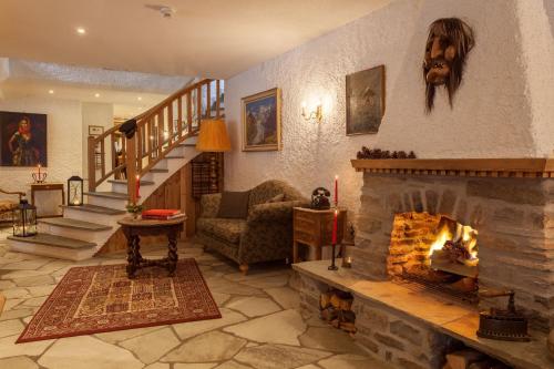 a living room with a fireplace and a staircase at Hotel Walliserhof Zermatt in Zermatt