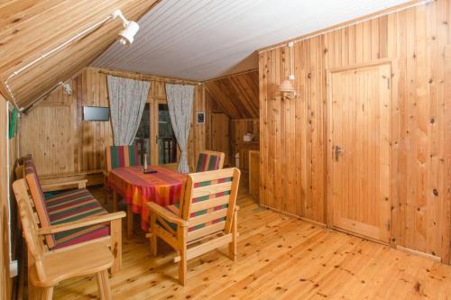 comedor con mesa, sillas y paredes de madera en Saare Manor Guesthouse en Saare