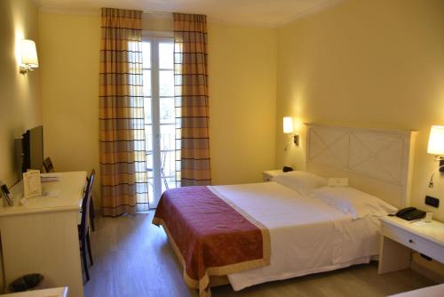 a hotel room with a large bed and a window at Hotel Villa Cappugi in Pistoia