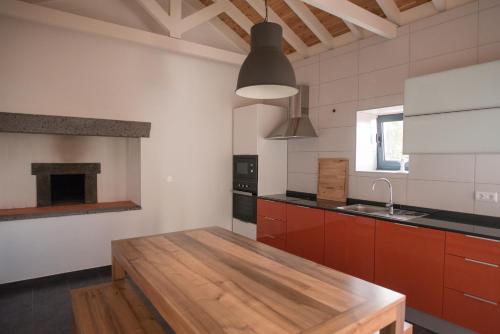 uma cozinha com uma mesa de madeira num quarto em Casa do Cedro do Mato em Terra Alta