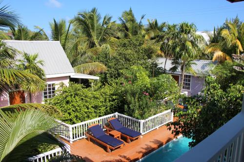 a balcony with two lounge chairs and a swimming pool at Weezie's Ocean Front Hotel and Garden Cottages in Caye Caulker