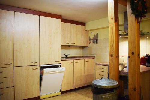 - une cuisine avec des placards en bois et un réfrigérateur blanc dans l'établissement Cozy room in Kaunas, à Kaunas