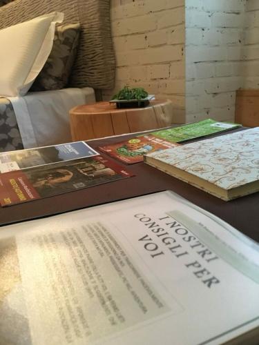 a table with a book and books on it at Suite Romantica Fuga in Roncone